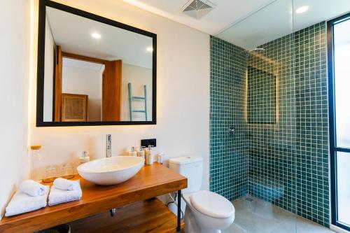 a bathroom with a sink and a toilet and a mirror at Villa Hati 2 in Canggu