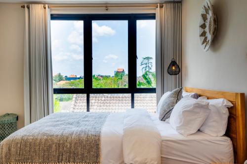 a bedroom with a bed and a large window at Villa Hati 2 in Canggu