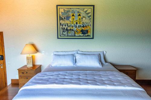 a bedroom with a bed and a picture on the wall at Mansão VOAR in Florianópolis