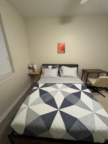 a bedroom with a black and white quilt on a bed at Charming Cedar Park Retreat - Cozy & Convenient Vacation Rental Near Austin in Cedar Park