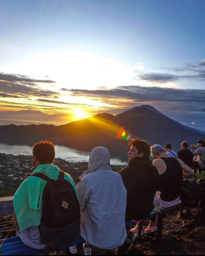 a group of people sitting on a bench watching the sunset at Ayra Batur Sunrise Jeep in Kubupenlokan