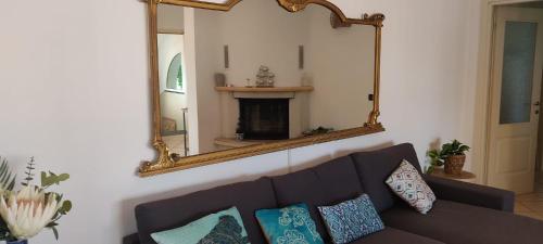 a living room with a couch and a mirror at Patty's House in Finale Ligure