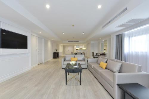 a living room with a couch and a tv at Centre Point Plus Hotel Silom - Newly Renovated in Bangkok