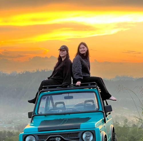 two women sitting on the roof of a car at Ayra Batur Sunrise Jeep in Kubupenlokan