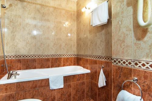 a bathroom with a bath tub and a sink at Hotel Izvor in Starozagorski Bani