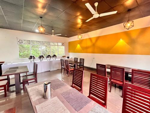 a restaurant with tables and chairs in a room at The Raarees Mist Resort, Munnar - Nested in Nature's Lap in Munnar