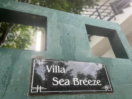 a sign on the side of a green wall at The Villa Sea Breeze in Talpe