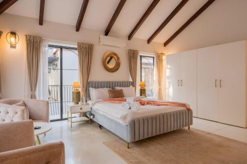 a bedroom with a bed and a couch at ELIVAAS Bogenvilla Luxe 3 BHK Villa Near Ozran Beach in Assagao