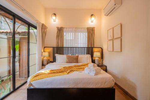 a bedroom with a large bed and a window at ELIVAAS Bogenvilla Luxe 3 BHK Villa Near Ozran Beach in Assagao