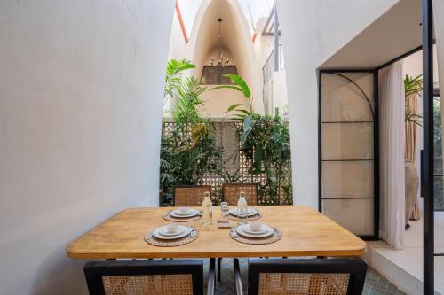 a wooden table and chairs in a room at ELIVAAS Bogenvilla Luxe 3 BHK Villa Near Ozran Beach in Assagao