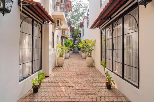 an alley with potted plants on the sides of buildings at ELIVAAS Bogenvilla Luxe 3 BHK Villa Near Ozran Beach in Assagao