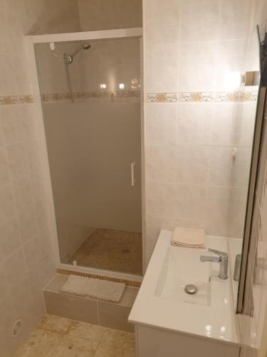 une salle de bain blanche avec une douche et un lavabo dans l'établissement les restanques du sud 2, au Lavandou