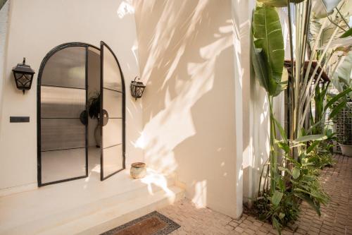 a hallway with a door and some plants at ELIVAAS Bogenvilla Luxe 3 BHK Villa Near Ozran Beach in Assagao