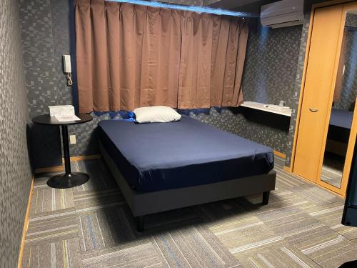 a bedroom with a bed and a phone on a table at ビジネスイン23 in Yokohama