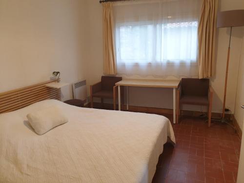 une chambre avec un lit, une table et des chaises dans l'établissement les restanques du sud 2, au Lavandou