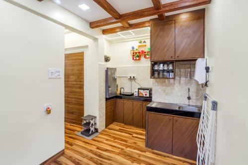 a kitchen with wooden flooring and wooden cabinets at Astra by The Bombay Home Company in Mumbai
