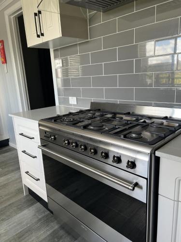 a kitchen with a stove top oven in a kitchen at Back Creek Estate Cottage in Severnlea