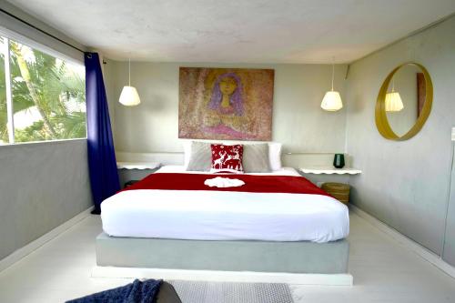 a bedroom with a large bed with a painting on the wall at Villa Valentine LomaBonitaLasTerrenas in Las Terrenas