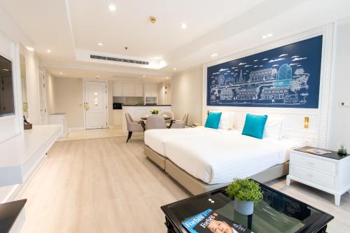 a bedroom with a large white bed and a table at Centre Point Plus Hotel Silom - Newly Renovated in Bangkok