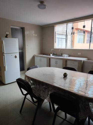 kuchnia ze stołem, krzesłami i lodówką w obiekcie Habitación familiar en el centro de Puno w mieście Puno