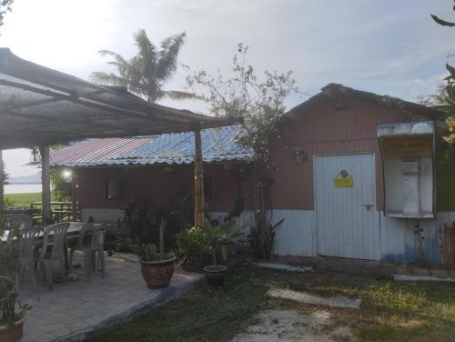 a red house with a white door and a patio at teriang minimal room in Pantai Kok