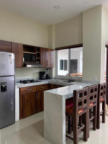 a kitchen with wooden cabinets and a stainless steel refrigerator at Casa Arizona in Brisas de Zicatela