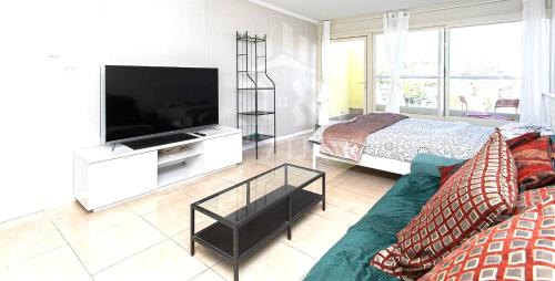 a living room with a television and a bed at Achuza near Horev renovated 3 room in Haifa