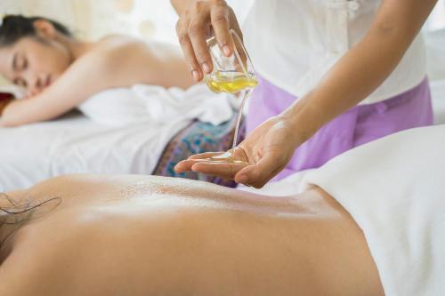 a woman receiving a massage with a glass of wine at Ferienhauspark Asgard in Damp in Damp