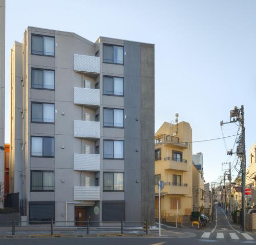an apartment building with balconies on a city street at japan house Ikebukuro 2 in Tokyo