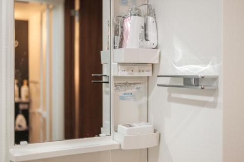 a bathroom with a mirror and a hair dryer at japan house Ikebukuro 2 in Tokyo