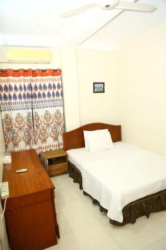 a room with two beds and a desk and a bed sidx sidx sidx at Maya Eco Guest House in Dhaka