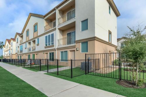 an apartment building with a fence in front of it at Charming Cedar Park Retreat - Cozy & Convenient Vacation Rental Near Austin in Cedar Park