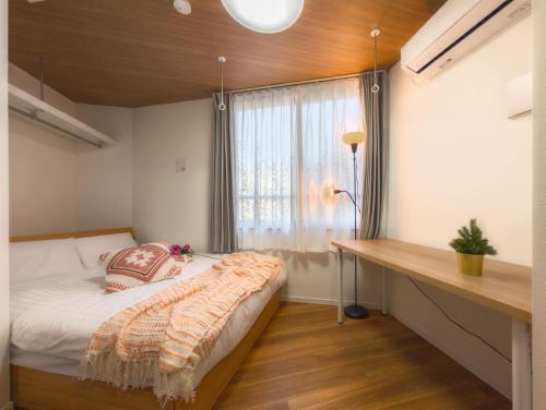a small bedroom with a bed and a window at japan house Ikebukuro 2 in Tokyo