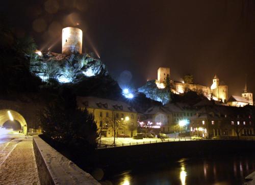 a castle on top of a mountain at night at Logis Gourmet & Relax Hotel De La Sure in Esch-sur-Sûre