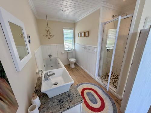un bagno bianco con lavandino e doccia di Beach house, Cannon Rocks, near Kenton-on-Sea a Cannon Rocks