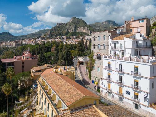 a view of a city with mountains in the background at Hotel Elios Tao in Taormina