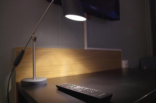 a remote control sitting on a desk next to a lamp at Hamarøy Hotel in Innhavet