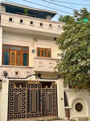 a white house with a gate in front of it at Om Kashi Villa in Varanasi