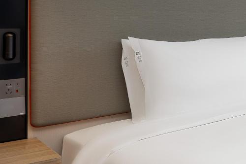 a close up of a bed with a pillow on it at Holiday Inn Express Suzhou City Center by IHG in Suzhou