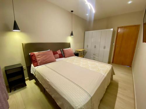 a bedroom with a large bed with pink pillows at Apartamento RR Agradable y Moderno c 2 dormitorios y estacionamiento interno techado in Ciudad del Este