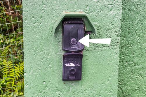 a parking meter on the side of a green wall at Mansão VOAR in Florianópolis