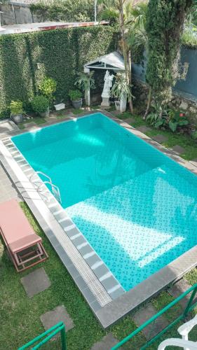 an empty swimming pool in a yard with a table at Villa Venetys Lembang by BWB in Cikidang 1