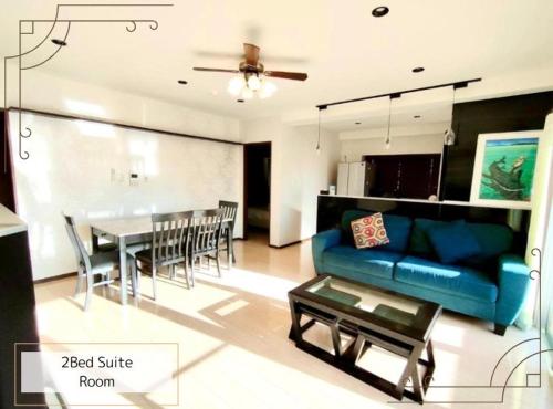 a living room with a blue couch and a table at Luana Uakoko Resort 旧 EmiFull Resort in Chatan