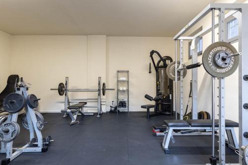 a gym with weights and other equipment in a room at Tuscasì Aparthotel in Sovicille
