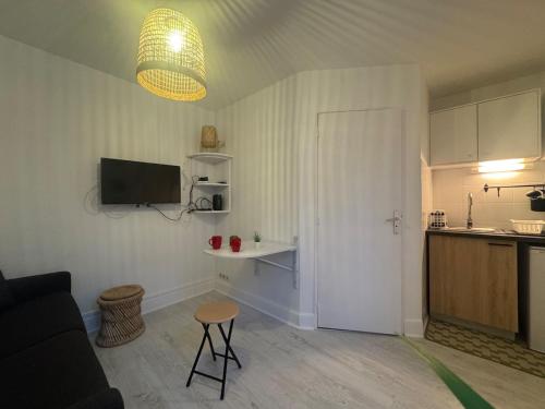 un salon avec un canapé et une table et une cuisine dans l'établissement Le Petit Bali - Studio, à Vichy