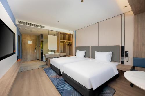 a hotel room with two beds and a flat screen tv at Holiday Inn Express Suzhou City Center by IHG in Suzhou