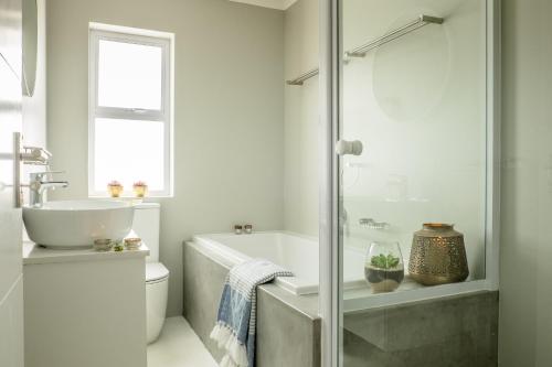a bathroom with a tub and a sink at Perlemoentjie in Britannia Bay