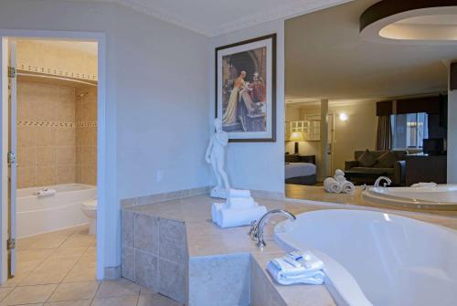 a bathroom with a bath tub and a sink at Travelodge by Wyndham Kamloops Mountview in Kamloops