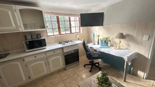a kitchen with a desk and a table with a chair at Artzys Flatlet in Northriding