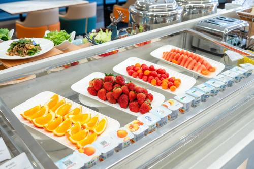 a refrigerator filled with plates of fruit and vegetables at Holiday Inn Express Suzhou City Center by IHG in Suzhou